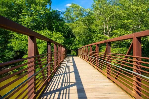 Pedestrian bridge with metal railings and green trees in Woodstock, Georgia